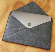 open grey felt pouch with silver laptop inside  
